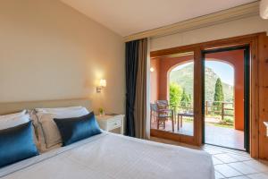 a bedroom with a large bed and a balcony at Boutique Hotel Torre Di Cala Piccola in Porto Santo Stefano