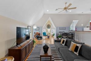a living room with a couch and a flat screen tv at The Uplifting Mansion in Milwaukee