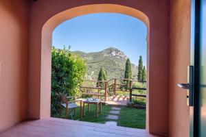 an open door to a patio with a table at Boutique Hotel Torre Di Cala Piccola in Porto Santo Stefano