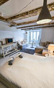 une chambre avec un grand lit et un salon dans l'établissement JoyJoyJoy the White Wilde ecolicious studio in a historic Canalhouse from 1799 with terrace at the canals, à Amsterdam