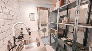 une cuisine avec un évier et un comptoir dans l'établissement JoyJoyJoy the White Wilde ecolicious studio in a historic Canalhouse from 1799 with terrace at the canals, à Amsterdam