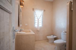 a bathroom with a toilet and a sink and a window at Mwezi - Maisha Resort in Watamu +53 photos