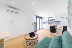 un salon avec un canapé et un ordinateur portable sur une table dans l'établissement TrendyHomes Palmeral Beach Mojacar, à La Marina de la Torre