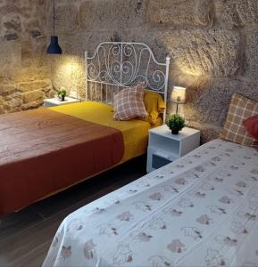 a bedroom with two beds and a stone wall at CASITA RECIEN HABILITADA A ESTRENAR CON PISCINA EN MALVAS Tuy in Malvas