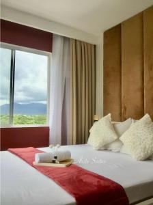 a bedroom with a large bed with a window at Aliste Suites Marina Spatial in Dumaguete +62 photos