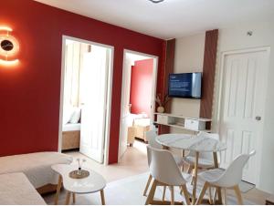 a living room with red walls and a table and chairs at Aliste Suites Marina Spatial in Dumaguete