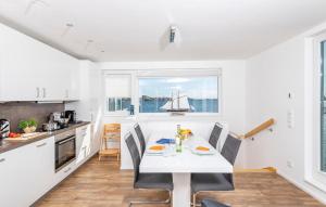 a kitchen with a white table and chairs and a boat in the window at Waterfront in Olpenitz