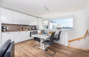 a kitchen with white cabinets and a table with chairs at Waterfront in Olpenitz +14 photos
