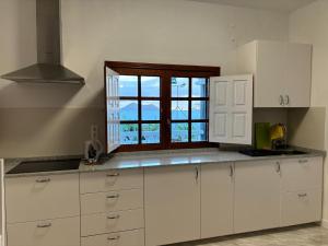 a kitchen with white cabinets and a window at Casa Siempreviva in Teguise