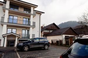 een zwarte auto geparkeerd op een parkeerplaats voor een huis bij Park Residence 2 in Sighetu Marmaţiei