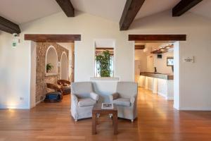 a living room with two chairs and a table at Boutique Hotel Torre Di Cala Piccola in Porto Santo Stefano