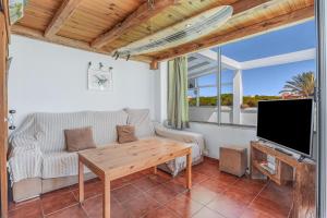 Agro Surf House في نوفو سانكتي بيتري: غرفة معيشة مع أريكة وتلفزيون وطاولة