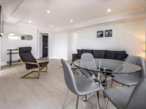 a living room with a glass table and chairs at Chelsea Cloisters Serviced Apartments in London