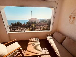 a living room with a couch and a large window at Serenity Seaview Suite Przno in Pržno