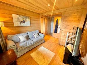a living room with a couch in a log cabin at Edenblanc in Arâches-la-Frasse