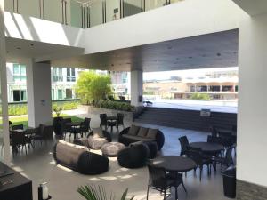 a lobby with couches and tables and chairs at Abreeza Place WIFI & Netflix in Davao City