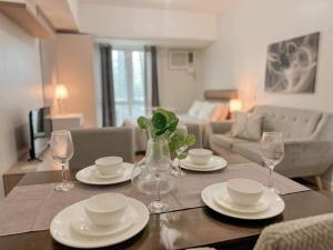a dining room table with plates and wine glasses at Abreeza Place WIFI & Netflix in Davao City +7 photos