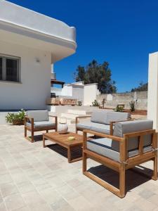 a patio with chairs and tables and a house at Apartment Emanuela in Porto Cesareo
