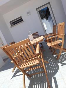 a group of wooden benches sitting in a room at Apartment Emanuela in Porto Cesareo