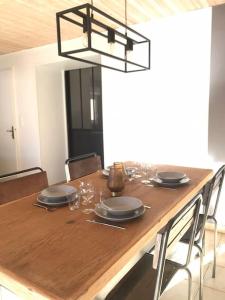 a dining room table with chairs and a light fixture at Le St Jean in Saint-Georges-sur-Eure +9 photos