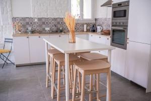 LOU DESTRE Maison 3 Chambres, parking vélo, Châteauneuf-du-Pape في شاتونوف-دو-باب: مطبخ مع طاولة مع كراسي و إناء من الزهور