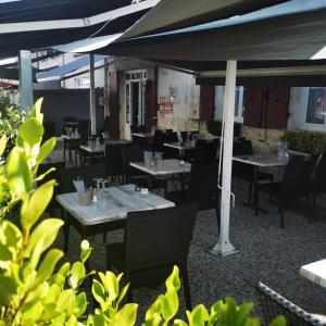 an empty restaurant with tables and chairs and tablesearcher at Logis Hôtel & Restaurant Le Saint Savinien in Saint-Savinien +50 photos