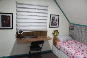 a small bedroom with a desk and a bed at Alojamiento Casa completa en Puerto Montt in Puerto Montt
