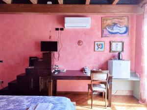 a bedroom with a desk in a pink wall at Villa Chiara Affascinante Villino in Monsampolo del Tronto