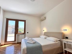 een witte slaapkamer met een bed en een raam bij Monte Urpinu Premium Apartment in Cagliari