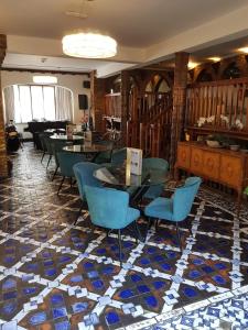 a lobby with blue chairs and tables on a mosaic floor at Madonna Halley Hotel in Edgware