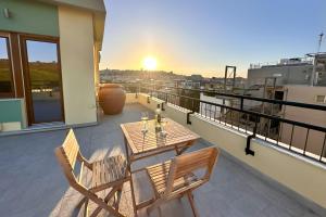 een terras met een tafel en stoelen op een balkon bij Monte Urpinu Premium Apartment in Cagliari
