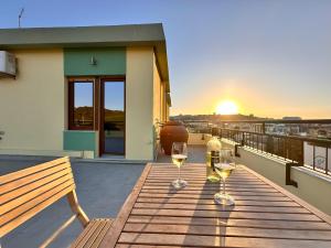 twee glazen wijn op een terras met de zonsondergang bij Monte Urpinu Premium Apartment in Cagliari +61 foto's