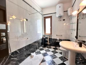 een zwart-witte badkamer met een wastafel en een toilet bij Monte Urpinu Premium Apartment in Cagliari
