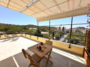 een terras met een tafel en stoelen op een balkon bij Monte Urpinu Premium Apartment in Cagliari
