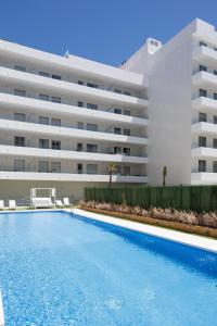 a swimming pool in front of a building at Ranhomes rentals apartments in Nueva Andalucia