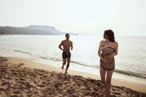 a man and a woman standing on the beach at Arina Beach Resort in Kokkíni Khánion