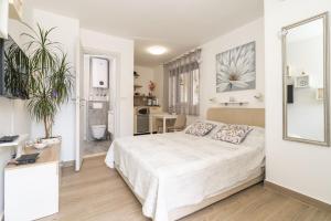 Un dormitorio blanco con una cama y un baño. en Studio Maro, en Dubrovnik