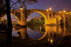 an old bridge over a river at night at Piso Estación Termal GARAJE Y AIRE ACONDICIONADO in Ourense +7 photos