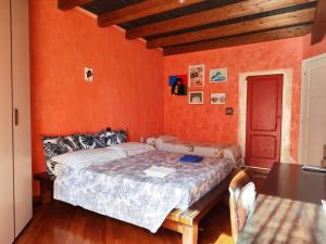 a bedroom with a bed with an orange wall at Villa Chiara Affascinante Villino in Monsampolo del Tronto