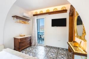 a bedroom with a bed and a mirror at Gorgona Traditional 3 in Karpathos Town