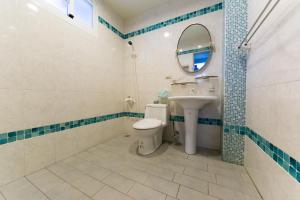 ein Badezimmer mit Toilette, Waschbecken und Spiegel in der Unterkunft Taitung Leisure B&B in Taitung + 22 Fotos