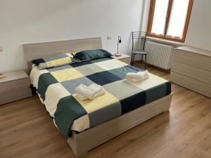 a bedroom with a large bed with two towels on it at Casa da Paolino in Porto Ceresio
