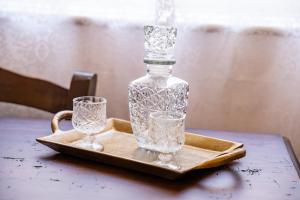 a glass bottle and two glasses on a tray at Gorgona Traditional 3 in Karpathos
