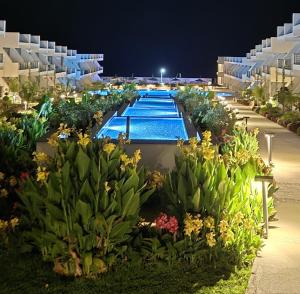 Un gran edificio con piscina por la noche. en Pearl Island apartments, en Kalogrea