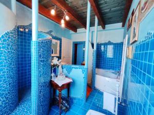 a blue bathroom with a tub and a sink at Villa Chiara Affascinante Villino in Monsampolo del Tronto +25 photos