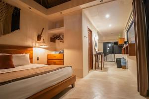 a bedroom with a bed and a small kitchen at Casa de Piedra - Departamentos Bacalar- in Bacalar +74 photos