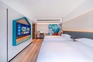 a bedroom with two beds and a flat screen tv at Echarm Hotel - Kunming Station South Asia Style Street Branch in Kunming +31 photos
