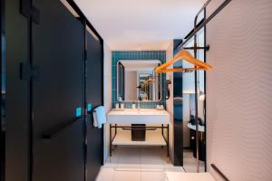 a bathroom with a sink and a mirror at Echarm Hotel - Kunming Station South Asia Style Street Branch in Kunming