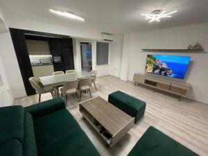 Una sala de estar con un sofá verde y una mesa. en Oskar Apartments 2, en Kočani