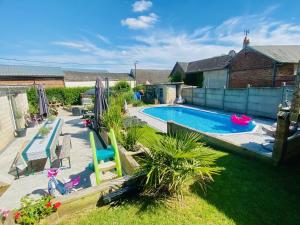 a backyard with a swimming pool and a yard with plants at Les 3 E in Englebelmer